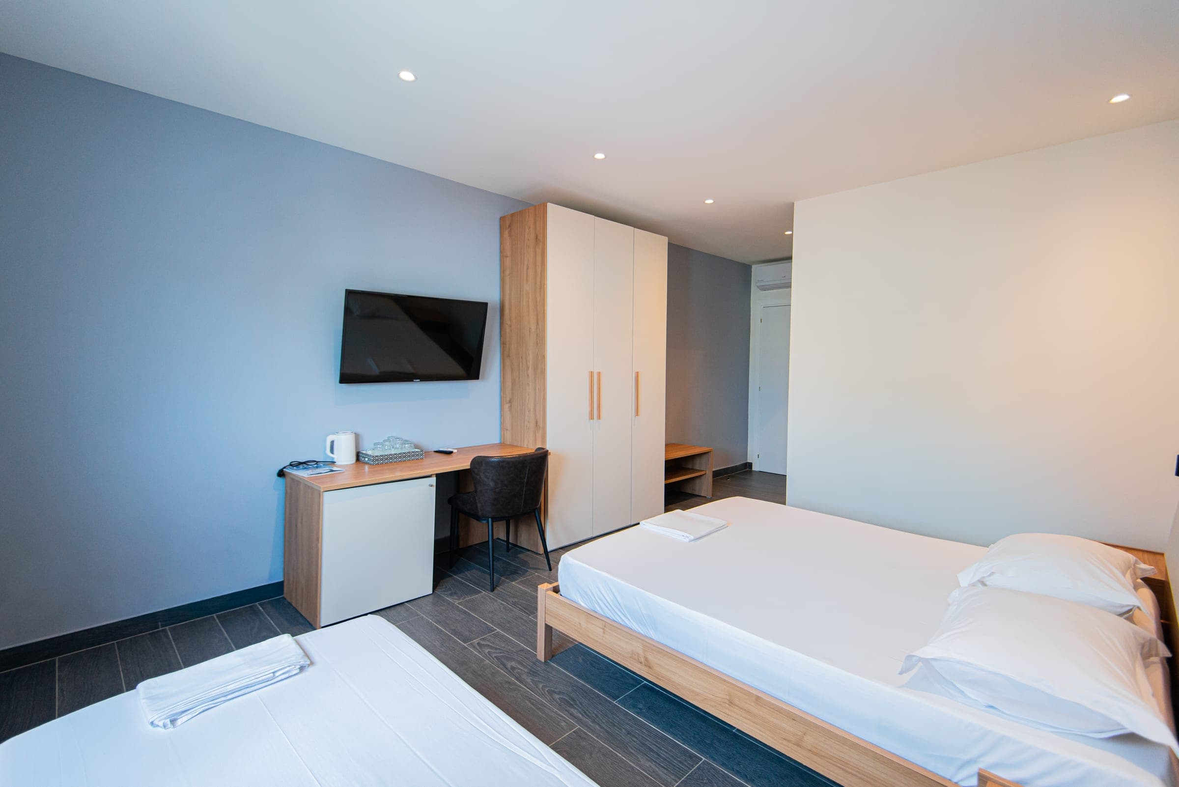 Triple Room with a TV, desk and wardrobe