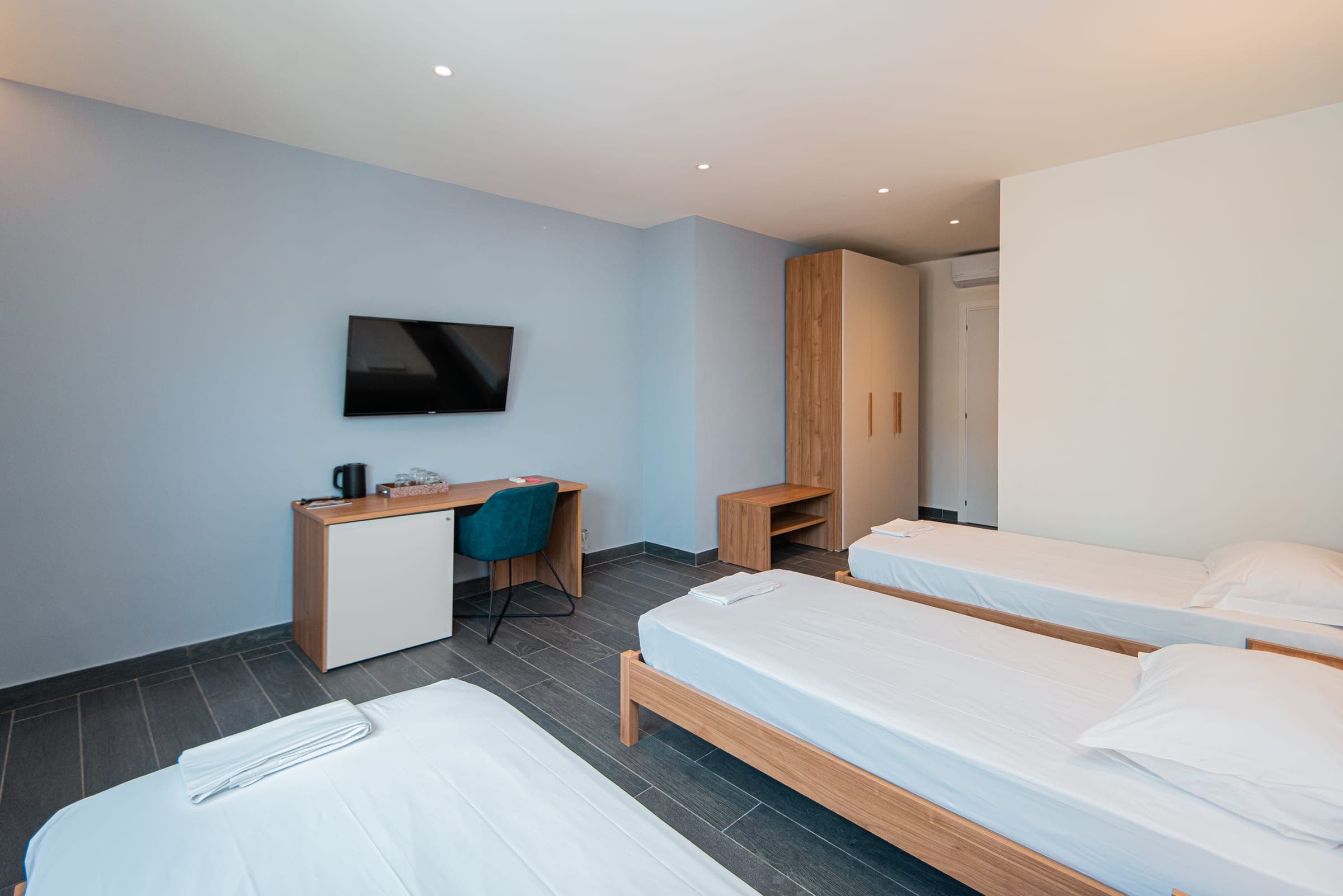 Triple Room with single beds, a TV and desk