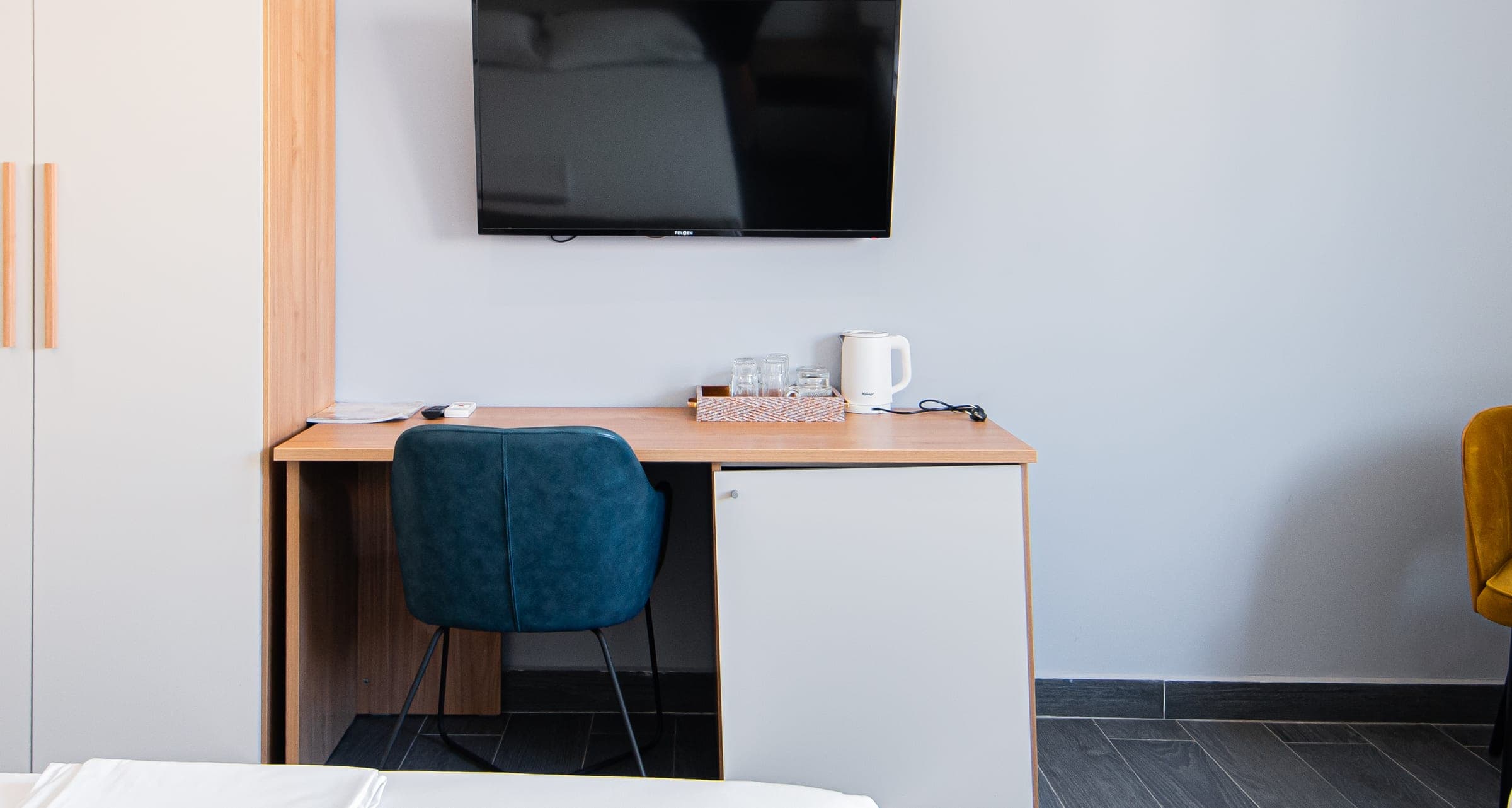 Desk with a chair, kettle and TV in a room at Amber Polka